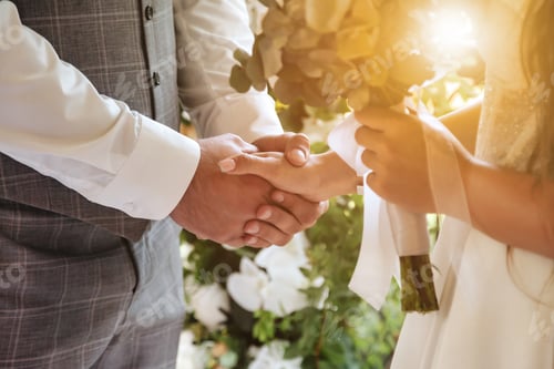 Preview: Close-up hands of fiancee (bride) and groom during wedding registration. Married couple holding hand