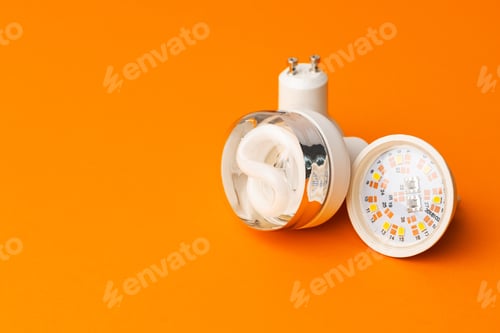 Preview: Light bulb on bright orange background top view