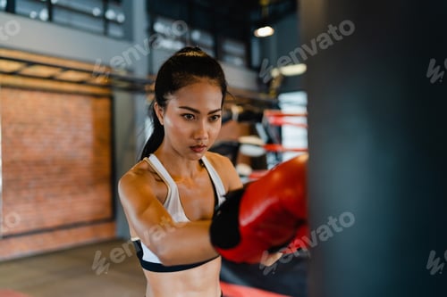 Preview: Asia lady kickboxing exercise workout punching bag tough female fighter practice boxing.