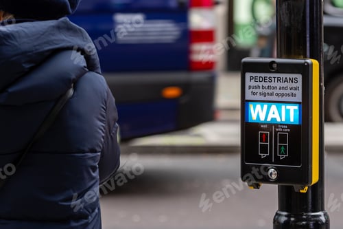 Preview: Crosswalk button for pedestrian with light warning on a defocused background, London, UK