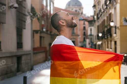 Preview: Radiant Man: Smiling under Sunset Glow, Holding LGBT Flag on Sunny City Street