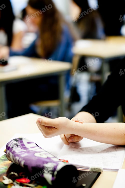 Preview: Cropped image of female student touching hand in classroom