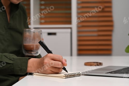 Preview: Young businessman drinking coffee and working at his home office.