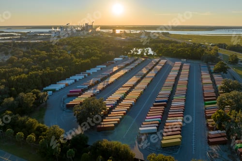 Preview: Aerial view of large cargo container yard with rows of freight containers and big factory