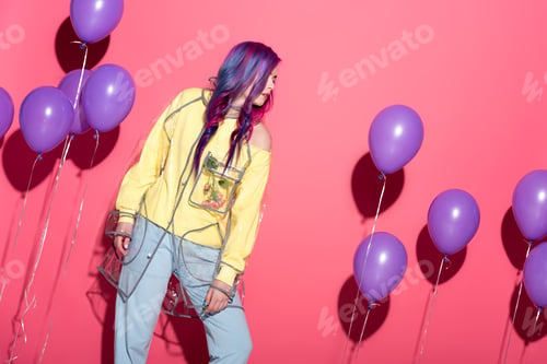 Preview: beautiful young woman in transparent raincoat with balloons on red