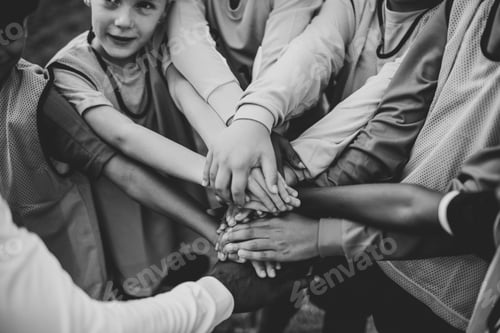 Preview: Junior football team stacking hands before a match