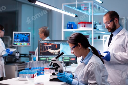 Preview: Woman scientist analyzing virus with microscope in research chemistry lab