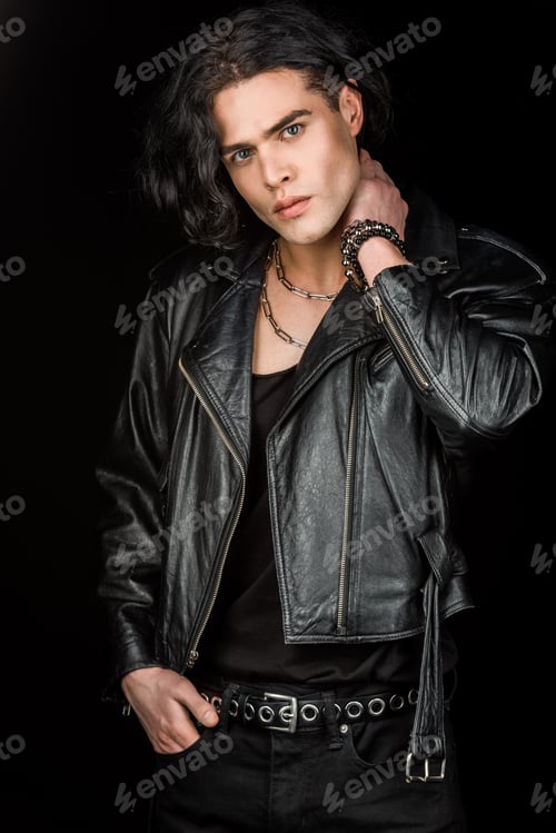 Preview: handsome man standing with hand in pocket and looking at camera isolated on black