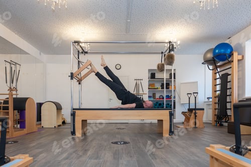 Preview: Male fitness Pilates trainer shows exercises on special simulators. Pilates Stretch Tables