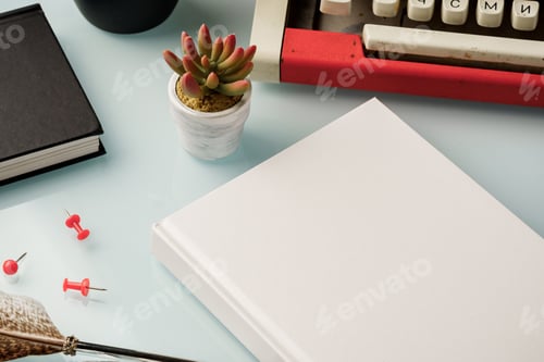 Preview: Hardcover book and vintage typewriter on white desk