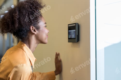 Preview: Woman using face scanner to unlock door in office building.