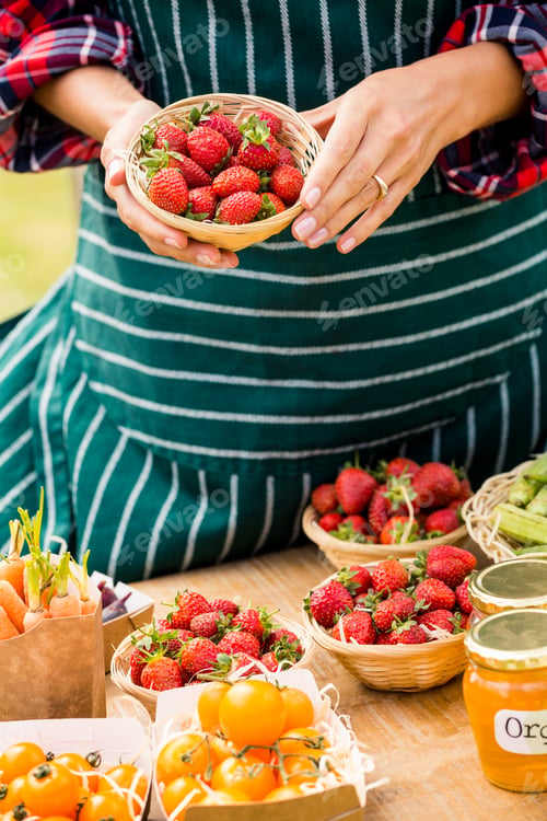Preview: Midsection of woman selling strawberries
