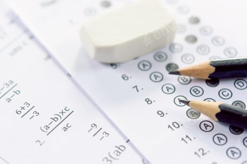 Preview: Pencil and eraser on answer sheets or Standardized test form with answers bubbled.