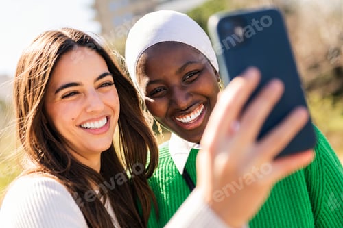 Preview: two friends smiling and having fun taking selfie