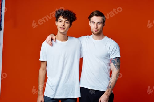 Preview: Two cheerful friends in white T-shirts are standing next to team emotions