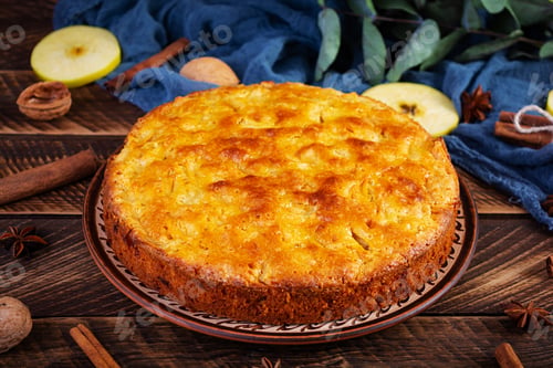 Preview: Delicious homemade apple pie on wooden background. Apple pie with ingredients, apples and cinnamon