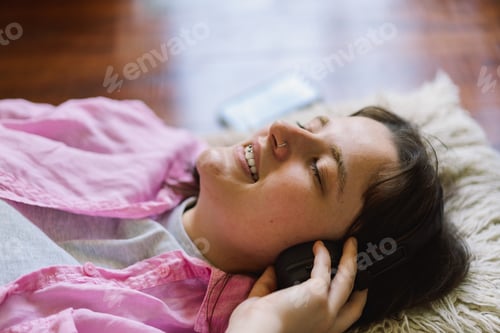 Preview: Teengirl Relaxing on the Floor With Headphones and a Drink
