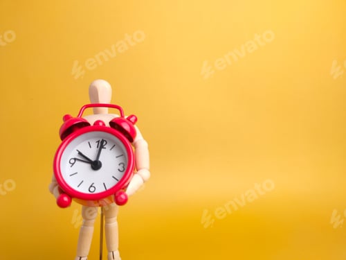 Preview: Wooden mannequin holding red alarm clock on a yellow background with copy space.