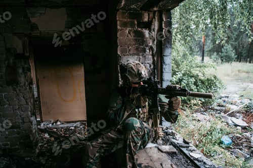 Preview: Soldier in camouflage with a military weapon aiming through the rifle sight through the window of an