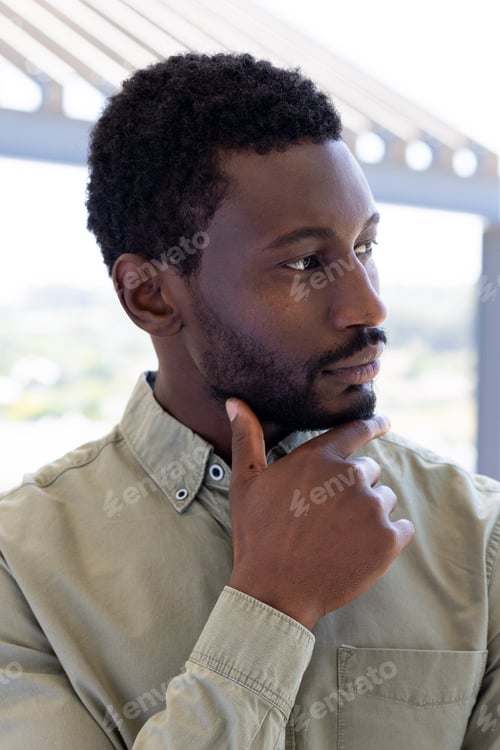 Preview: African american businessman thinking and touching his chin outside modern office