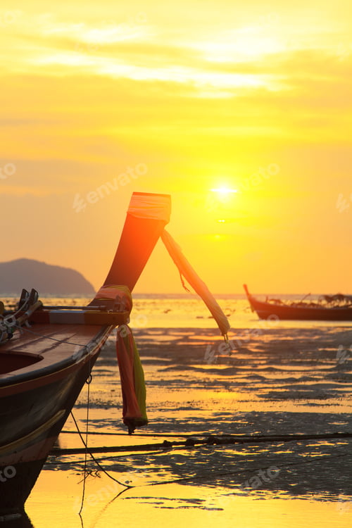 Preview: Longtail Boat Silhouetted at Sunrise on Exotic Beach