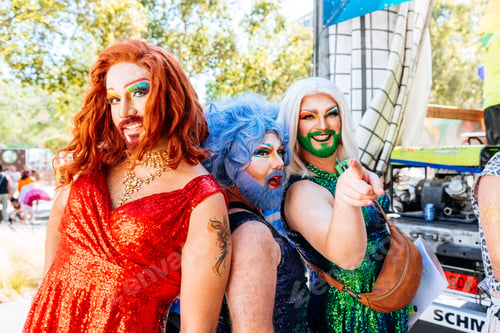 Preview: Cheerful group of drag queens in elegant outfit at pride party
