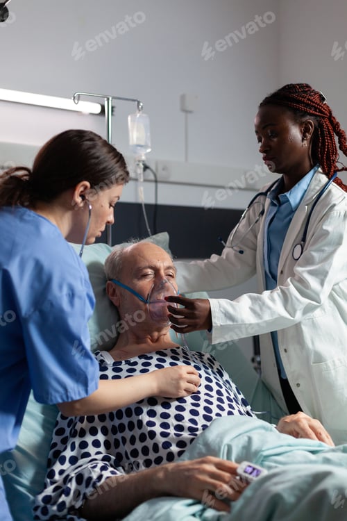 Preview: African doctor and medical assistant helping senior man breath