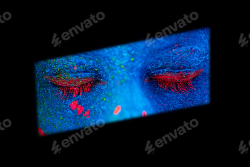 Preview: Shes a mystery. Shot of a young woman posing with neon paint on her face.