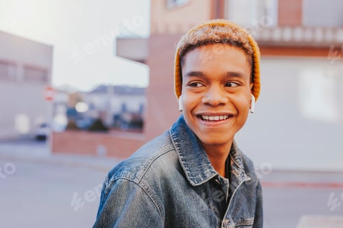 Preview: Young afro latin boy listens music with earphones outdoors
