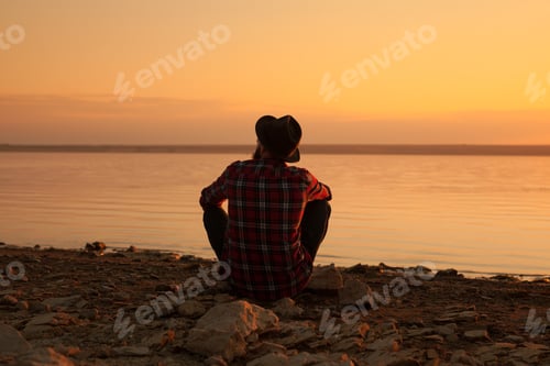 Preview: Man sitting at river
