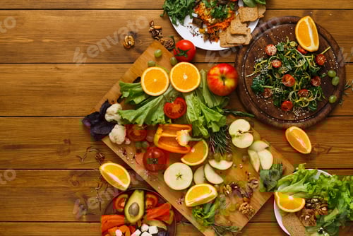 Preview: Wooden table served with cut fruits and vegetables