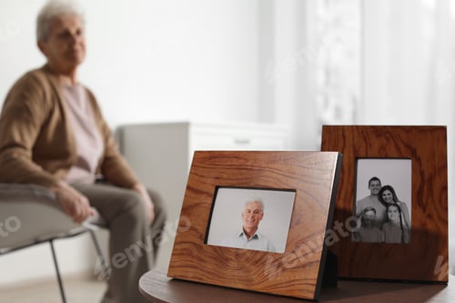 Preview: Framed photos and blurred female pensioner on background. Space for text