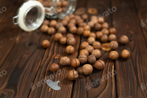 Preview: Macadamia nut close-up on brown wood background.