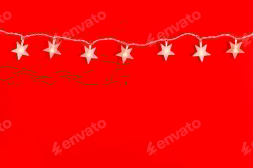 Preview: Garland in the form of star on a red background with copy space. Flat lay, top view