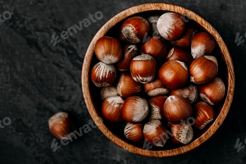 Preview: Hazelnuts. Whole Hazelnuts in wooden bowl on dark background