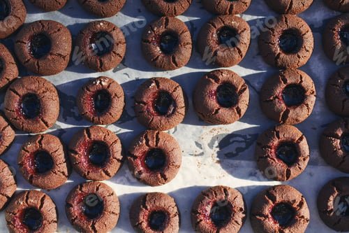 Preview: High angle view on baking tray with one missing homemade cocoa cookie.