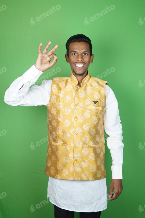 Preview: Indian boy showing OK and smiling on the green background