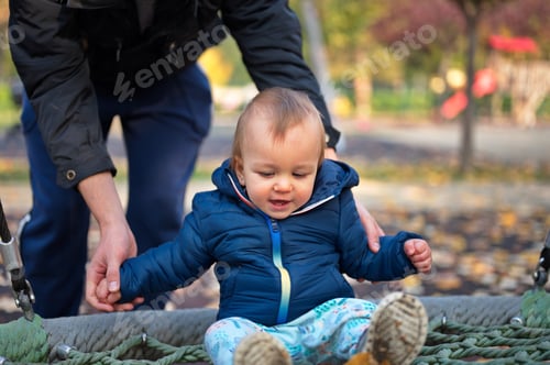 Preview: Midsection of father playing with his cute little boy on playground