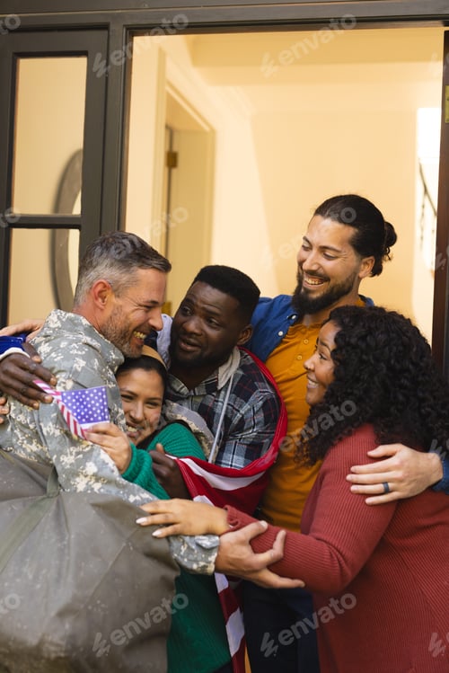 Preview: Happy diverse friends with flags welcoming home male soldier friend