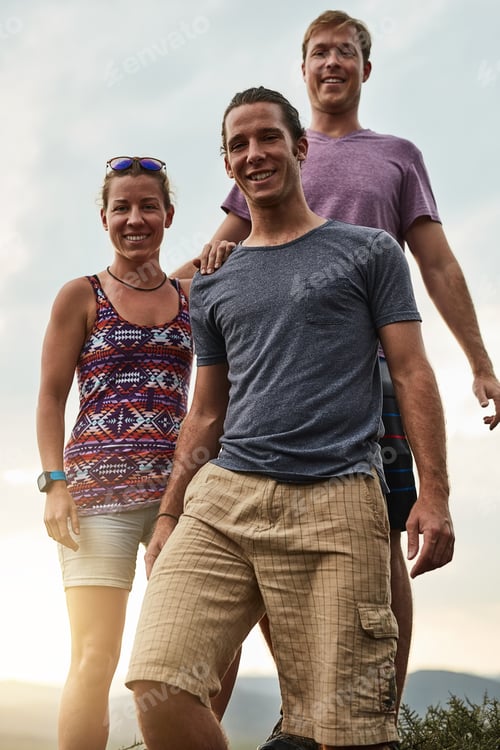Preview: Portrait of three happy friends posing together during a hike in the mountains