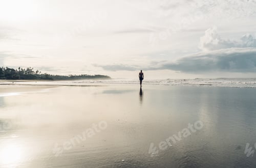 Preview: Unrecognizable man walking on wet beach