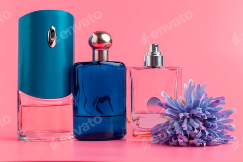 Vista previa: Perfume bottles on pastel pink background close up