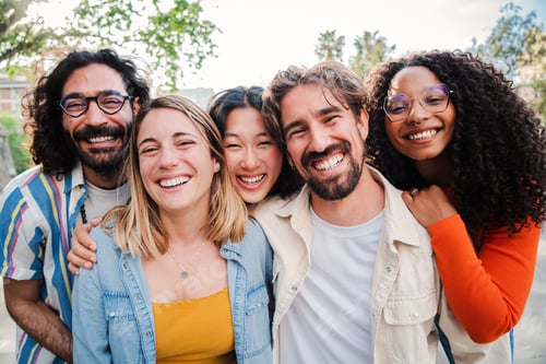 Preview: Portrait of a group of friends laughing together and looking at camera. Five young multiracial