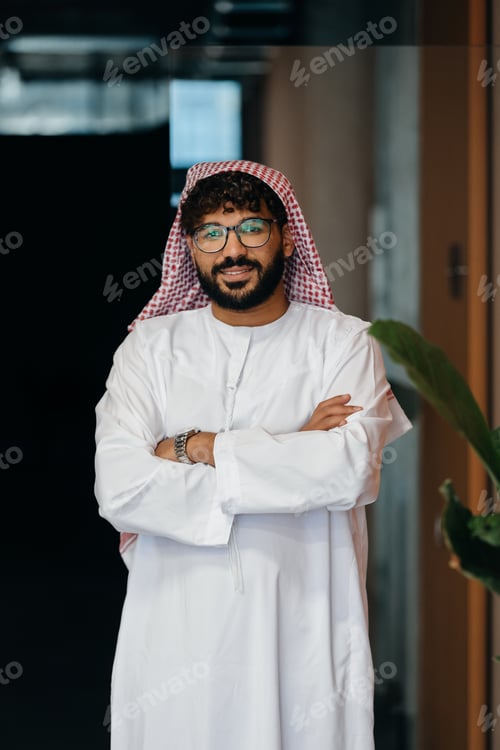 Preview: Middle eastern businessman in traditional attire smiling at camera
