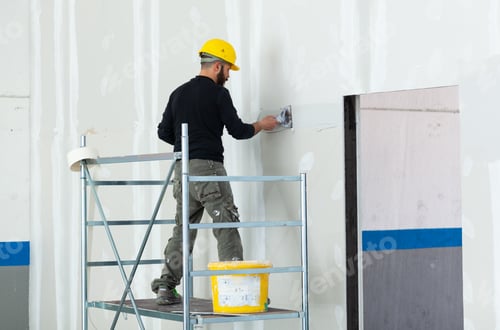 Preview: worker plastering gypsum board wall.