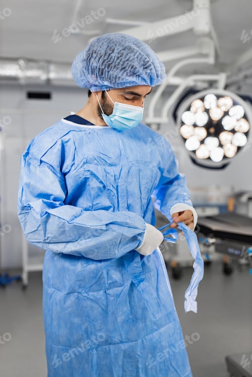 Preview: Surgeon in Surgical Gown Tying Up Straps