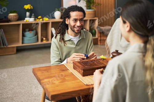 Preview: Young Adult Man Engaging in Traditional Asian Tea Ceremony with Woman