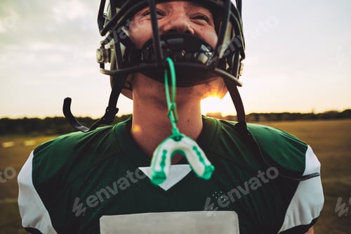 Preview: Young American football player standing on a field during practice