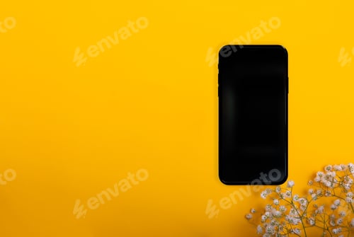 Preview: Black smartphone isolated on a yellow background with copy space