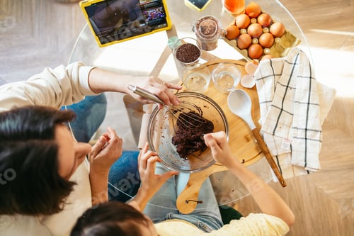 Preview: Mom and daughter baking chocolate cookies together following online recipe